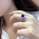 Load image into Gallery viewer, Sapphire and diamond ring on a person’s finger.
