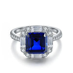 Load image into Gallery viewer, Sapphire and diamond engagement ring with a square-cut center stone.
