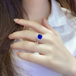 Load image into Gallery viewer, Sapphire ring with diamond accents on a person’s hand.
