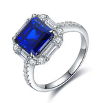 Load image into Gallery viewer, Sapphire and diamond engagement ring with a square-cut center stone.
