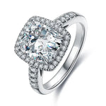 Load image into Gallery viewer, Cushion-cut diamond engagement ring with a halo setting and pave band.
