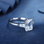 Load image into Gallery viewer, Diamond engagement ring with an emerald-cut center stone and tapered baguette side stones.
