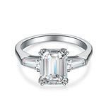 Load image into Gallery viewer, Diamond engagement ring with an emerald-cut center stone and tapered baguette side stones.
