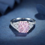 Load image into Gallery viewer, Engagement ring featuring a square-cut pink diamond center stone flanked by smaller white diamonds on the band.
