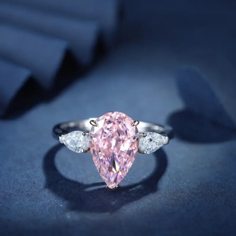 Elegant ring featuring a pear-shaped pink diamond flanked by two white diamonds.