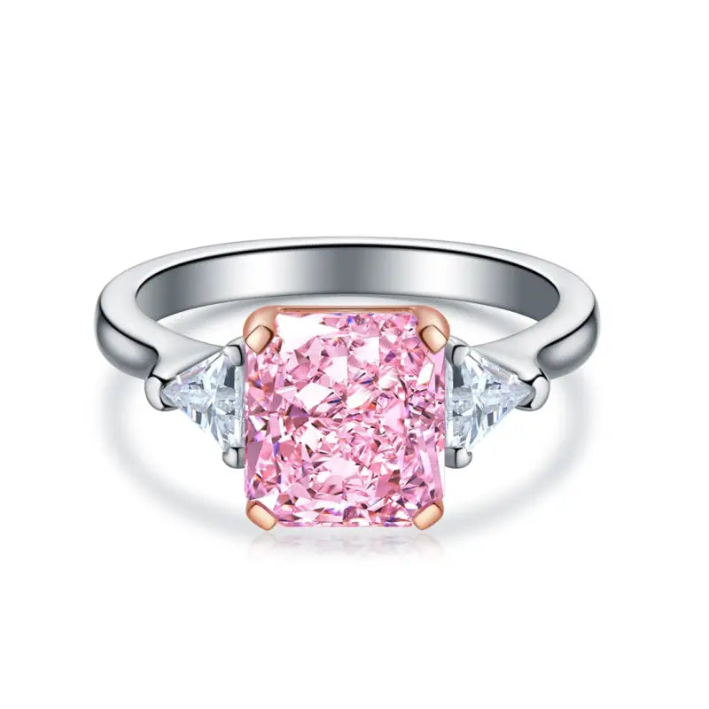 Engagement ring featuring a pink rectangular diamond center stone flanked by two smaller white diamonds.