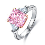 Load image into Gallery viewer, Engagement ring featuring a pink cushion-cut diamond center stone flanked by two triangular diamonds.
