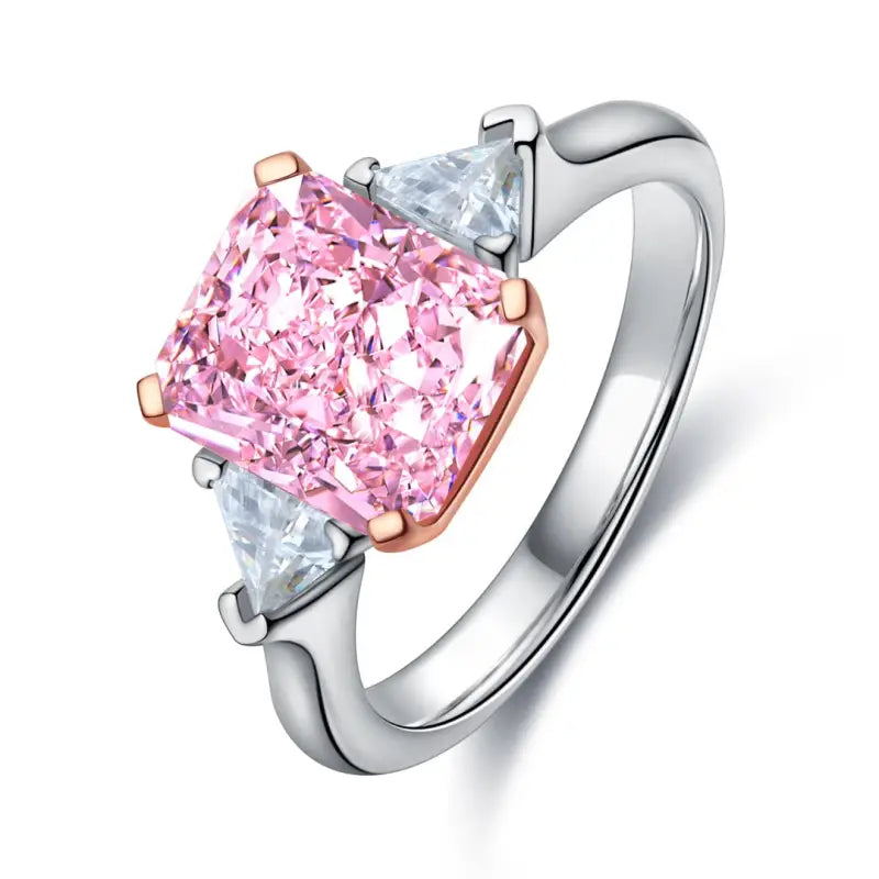 Engagement ring featuring a pink cushion-cut diamond center stone flanked by two triangular diamonds.