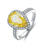 Load image into Gallery viewer, Pear-shaped yellow gemstone ring with diamond halo and band.
