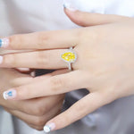 Load image into Gallery viewer, Yellow diamond ring with a halo of smaller diamonds set in a white metal band.
