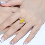 Load image into Gallery viewer, Yellow diamond ring with side stones on a person’s hand.
