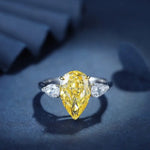 Load image into Gallery viewer, Pear-shaped yellow diamond ring with white diamond side stones.
