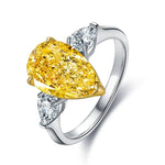 Load image into Gallery viewer, Elegant ring featuring a pear-shaped yellow diamond flanked by two white diamonds.
