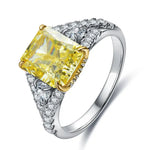 Load image into Gallery viewer, Engagement ring featuring a square-cut yellow diamond center stone surrounded by smaller white diamonds on a silver band.
