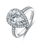 Load image into Gallery viewer, Pear-shaped diamond engagement ring with a halo setting and pavé band.
