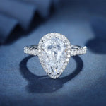 Load image into Gallery viewer, Pear-shaped diamond engagement ring with a halo setting and pavé band.
