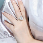 Load image into Gallery viewer, Teardrop-shaped diamond engagement ring on a woman’s finger.
