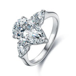 Load image into Gallery viewer, Diamond engagement ring featuring a pear-shaped center stone flanked by two smaller pear-cut diamonds.
