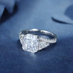 Load image into Gallery viewer, Diamond engagement ring with a prominent square-cut center stone and smaller side diamonds.
