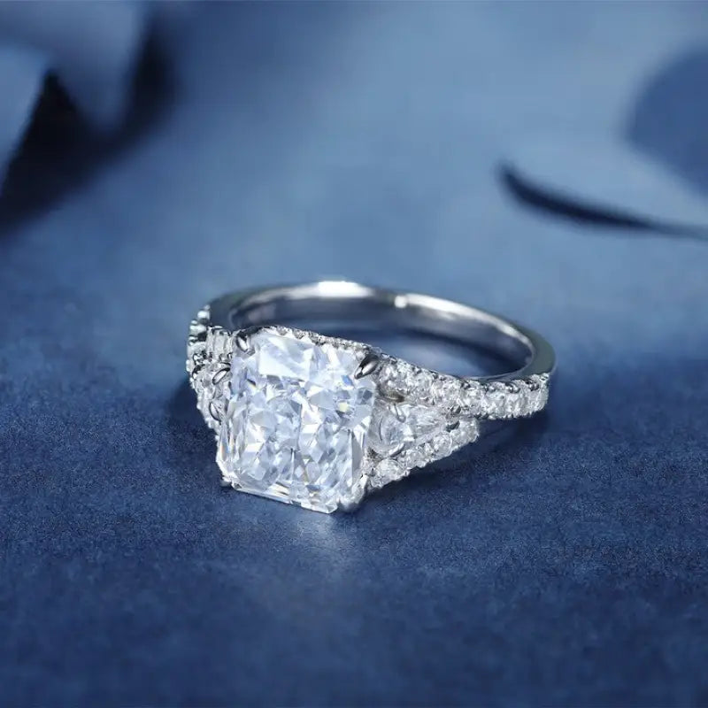 Diamond engagement ring with a prominent square-cut center stone and smaller side diamonds.