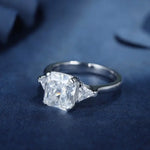 Load image into Gallery viewer, Diamond engagement ring with a prominent square-cut center stone and smaller triangular side stones.
