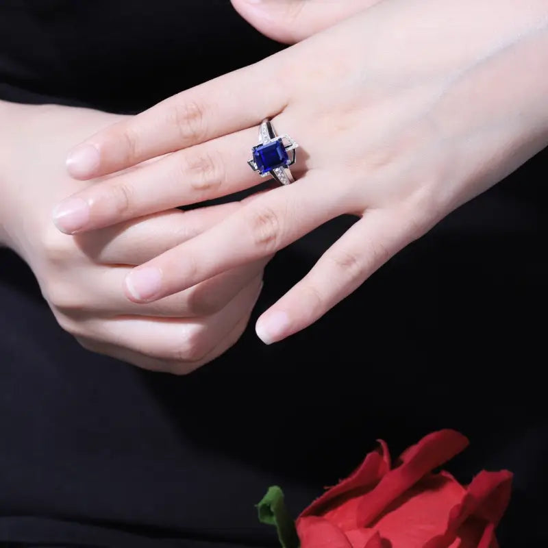 Sapphire and diamond ring on a person’s hand.