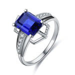 Load image into Gallery viewer, Elegant silver ring featuring a vibrant blue rectangular gemstone surrounded by small diamonds.
