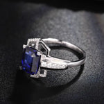 Load image into Gallery viewer, Elegant silver ring featuring a deep blue square-cut gemstone surrounded by small diamonds.
