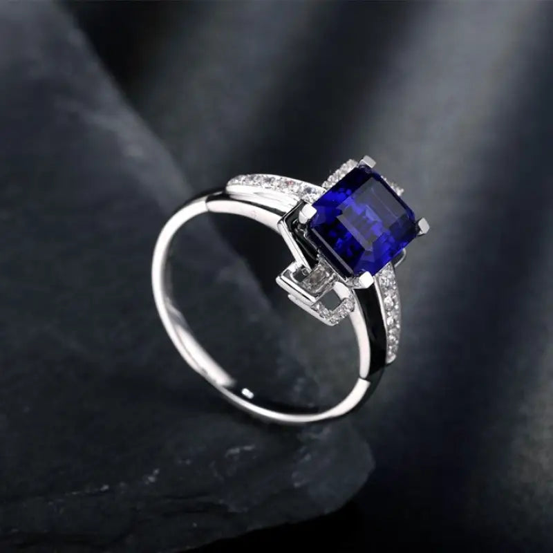 Silver ring featuring a square-cut blue sapphire gemstone and small diamonds.