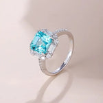 Load image into Gallery viewer, Elegant silver ring featuring a square-cut aquamarine gemstone surrounded by small diamonds.
