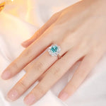 Load image into Gallery viewer, Ornate ring featuring a teal gemstone surrounded by smaller clear stones.
