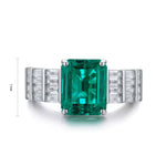 Load image into Gallery viewer, Emerald-cut green gemstone ring with diamond accents on a white gold band.
