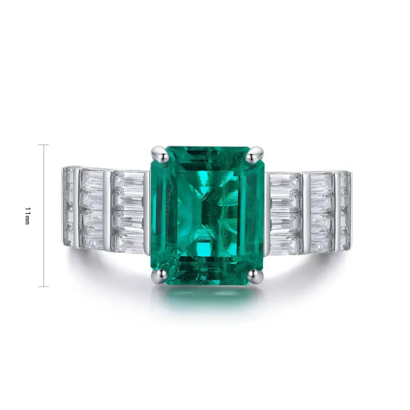 Emerald-cut green gemstone ring with diamond accents on a white gold band.