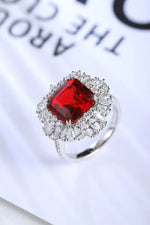 Load image into Gallery viewer, Ornate silver ring featuring a square-cut red gemstone surrounded by smaller clear stones.
