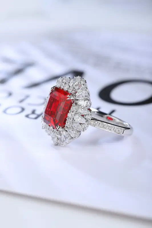 Elegant ring featuring a rectangular red gemstone surrounded by small diamonds.