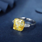 Load image into Gallery viewer, Yellow diamond engagement ring with baguette side stones on a silver band.
