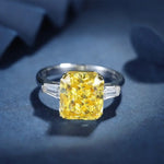 Load image into Gallery viewer, Yellow diamond engagement ring with tapered baguette side stones set in a platinum band.
