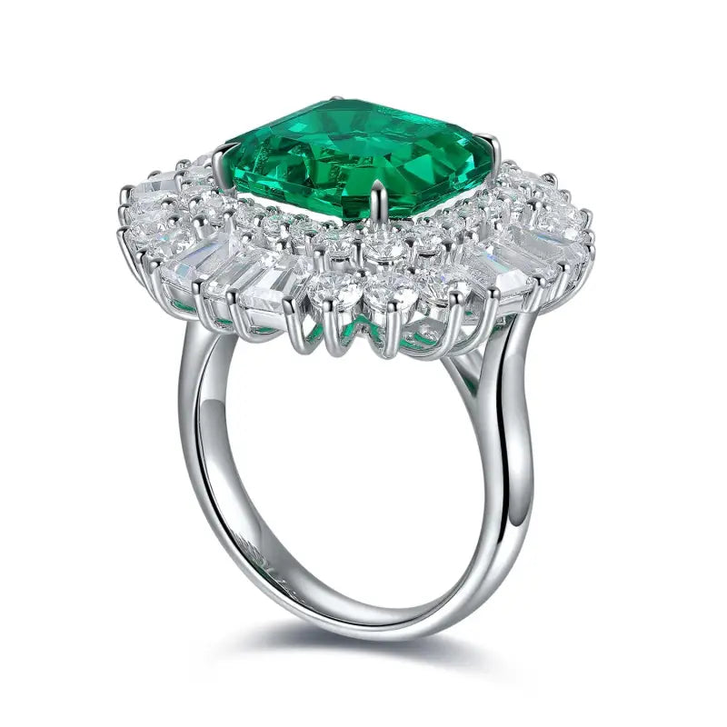 Ornate silver ring featuring a prominent emerald-green gemstone surrounded by smaller diamonds.