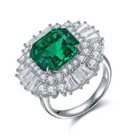 Load image into Gallery viewer, Ornate silver ring featuring a prominent emerald-cut green gemstone surrounded by diamonds.
