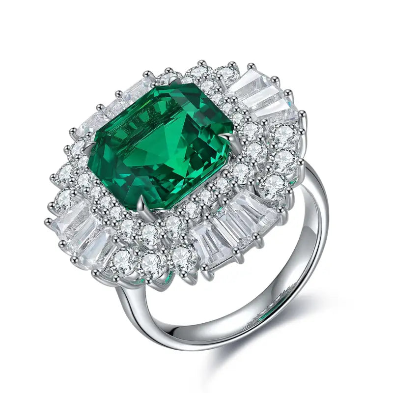 Ornate silver ring featuring a prominent emerald-cut green gemstone surrounded by diamonds.