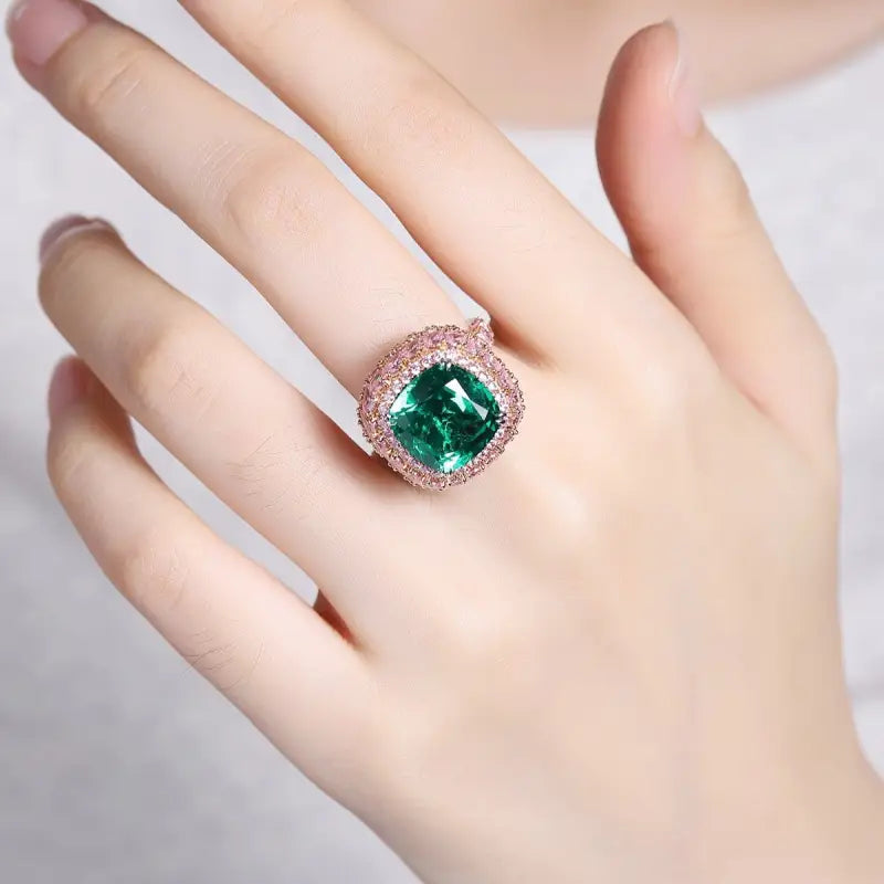 Ornate ring featuring a cushion-cut emerald surrounded by diamonds.