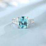 Load image into Gallery viewer, Aquamarine gemstone ring with diamond side stones set in a silver or white gold band.
