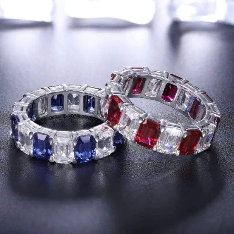 Two gemstone-encrusted eternity bands featuring alternating colored and clear stones.