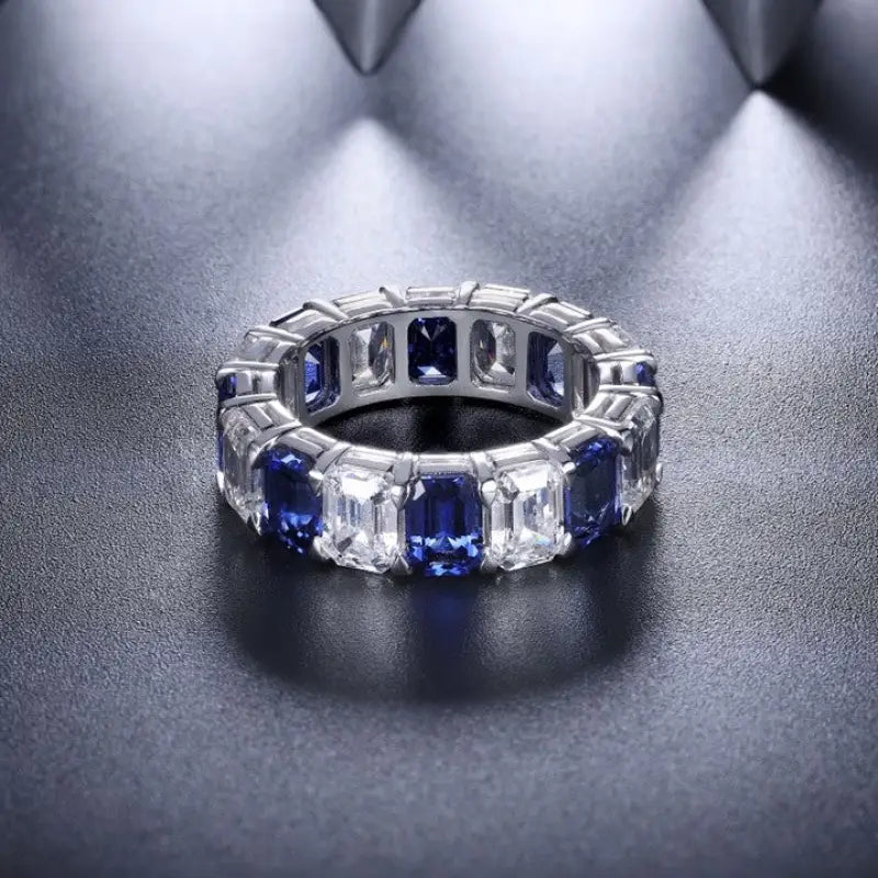 Elegant eternity ring featuring alternating sapphire and diamond gemstones.