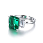 Load image into Gallery viewer, Emerald-cut gemstone ring with a vibrant green center stone and side diamonds.
