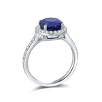 Load image into Gallery viewer, Elegant silver ring featuring a deep blue oval gemstone surrounded by small diamonds.
