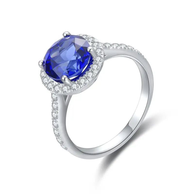 Elegant silver ring featuring a deep blue gemstone surrounded by small diamonds.