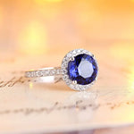 Load image into Gallery viewer, Sapphire and diamond halo engagement ring with a white gold band.
