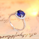 Load image into Gallery viewer, Elegant silver ring featuring a deep blue gemstone surrounded by small diamonds.
