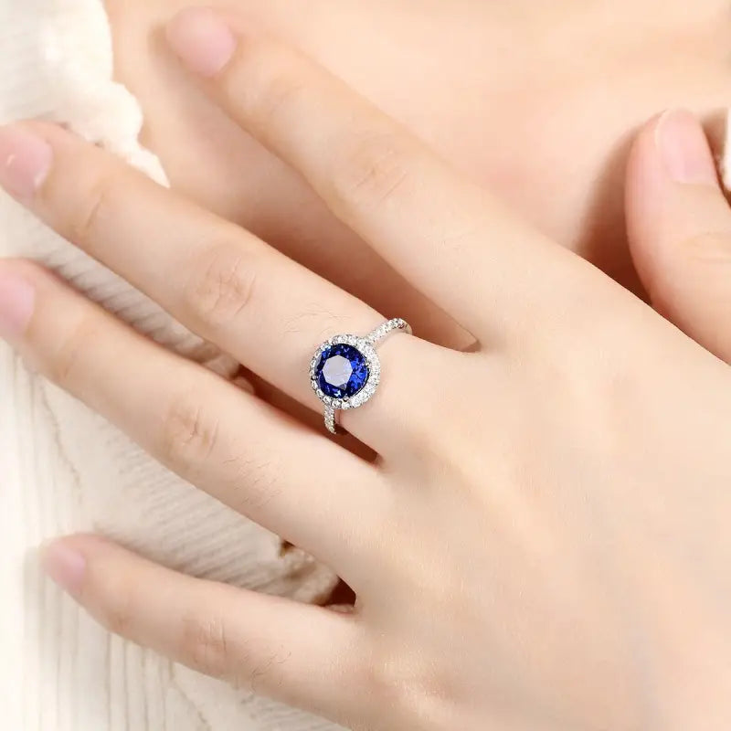 Sapphire and diamond ring on a person’s finger.